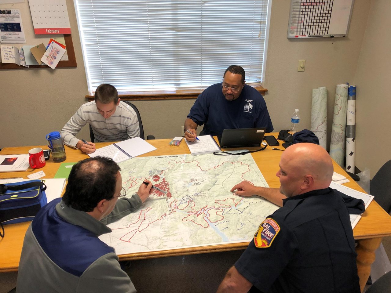 A wildfire planning team reviewing a marked map together
